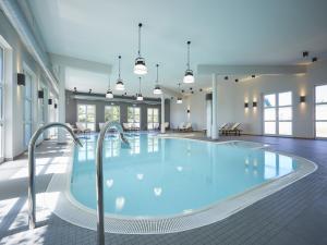 德兰斯克Reetland am Meer - Luxus Reetdachvilla mit 3 Schlafzimmern, Sauna und Kamin E27的大楼里一个蓝色的大泳池