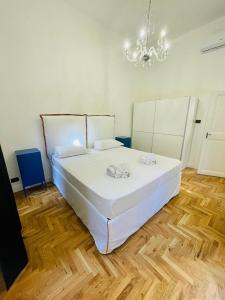 罗马Central Suite的卧室配有白色的床和吊灯。