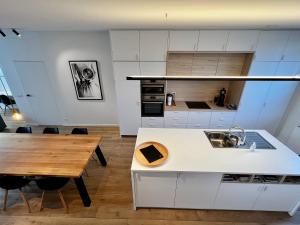 布鲁日Ferias - cosy house的厨房配有白色橱柜和木桌