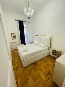 罗马Central Suite的卧室配有白色的床,铺有木地板