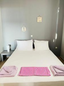 斯卡拉卡里拉奇斯Seaside Deluxe Apartment的一张白色大床,上面有粉色和白色的毛巾