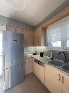 斯卡拉卡里拉奇斯Seaside Deluxe Apartment的厨房配有不锈钢冰箱和水槽