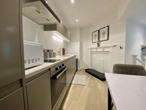 利物浦Luxeurs - Victoria Street Apartments的一间带柜台和炉灶的厨房 顶部烤箱