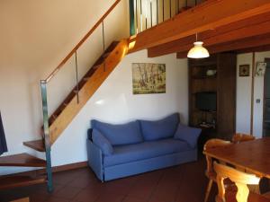 Grazzano BadoglioHoliday Home Le Rose Rosse by Interhome的客厅设有蓝色的沙发和楼梯。