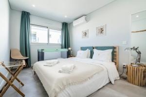 蒙蒂戈杜Coastal Holiday´s Apartment的卧室配有一张白色大床和一把椅子