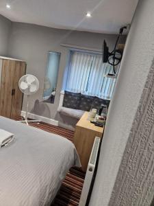 哈利法克斯谢尔斯宾馆的一间卧室配有一张床、一台电视和一张沙发