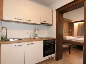菲根Apartment Römerhof-5 by Interhome的厨房配有白色橱柜、水槽和床。