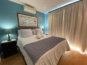布鲁堡史特兰Imany Guest House的一间卧室配有一张带蓝色墙壁的大床