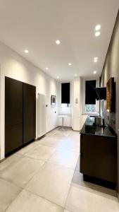 米兰费鲁奇街22号公寓的一间设有黑色橱柜和瓷砖地板的大厨房