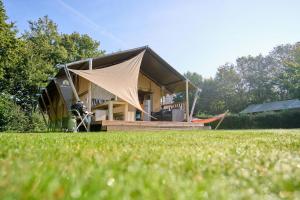 代讷坎普Glamping Twente的草场上带帐篷的房子