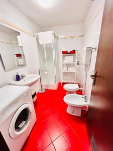 博洛尼亚法尔科内22号公寓的红色的浴室设有2个卫生间和洗衣机。