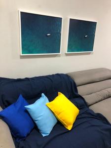 萨尔瓦多Cobertura Armação的一张蓝色的沙发,上面有四个枕头