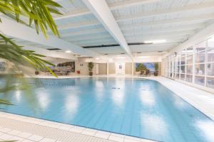 卡兰茨奥赫卡兰茨奥赫弗莱彻酒店的一座带大型天花板的建筑中的游泳池