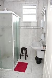 库里提巴Joshua Tree Hostel - Curitiba的带淋浴、盥洗盆和凳子的浴室