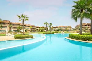 马拉喀什Résidence Golfique PJ, jardin, piscine的度假村内一座种有棕榈树的大型游泳池