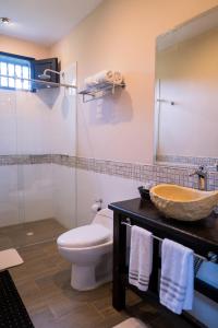 波帕扬Hotel Hacienda Supracafe的一间带卫生间、水槽和镜子的浴室