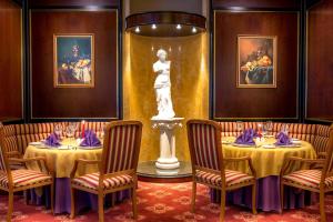 什切青丽笙布鲁什切青酒店的一间设有两张桌子和雕像的用餐室