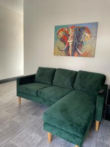 米德尔斯伯勒Byelands Lodge的客厅里一张绿色沙发,上面有大象的画作