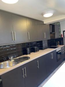 米德尔斯伯勒Byelands Lodge的厨房配有黑色橱柜和水槽