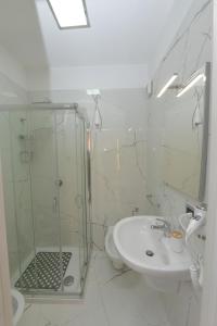 莫杜尼奥Noemi B&B的一间带玻璃淋浴和水槽的浴室