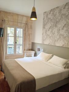 波尔多L'Apparthôtel Particulier Bordeaux的卧室设有一张白色大床和一扇窗户。