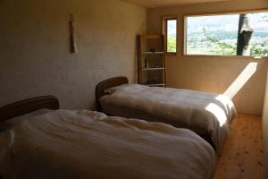 南阿苏村青い空と白い龍的带窗户的客房内的两张床