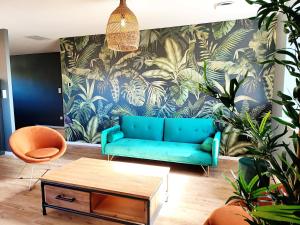 贝格海姆L'Horizon的客厅配有蓝色沙发和植物