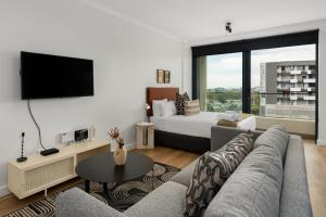 开普敦Newlands Peak Aparthotel by Totalstay的带沙发、电视和床的客厅
