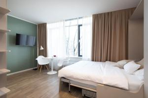 慕尼黑Brera Serviced Apartments Munich West的一间卧室配有一张床、一张书桌和一个窗户。