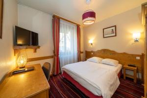 尼德布龙莱班Hôtel du Parc, Restaurant, Spa & Wellness的酒店客房配有一张床、一张书桌和一台电视。