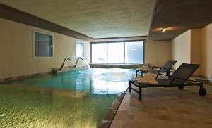 法申勒布朗克温泉酒店的一个带两把椅子的大型游泳池