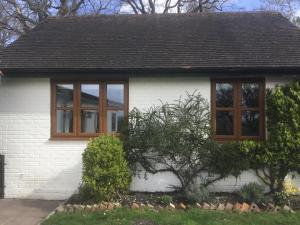 亚特利Cute Cottage 2024 Traveller Award的白色的房子,有两个窗户