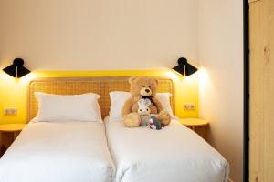 普罗旺斯艾克斯Hôtel Escaletto的睡在床上的泰迪熊