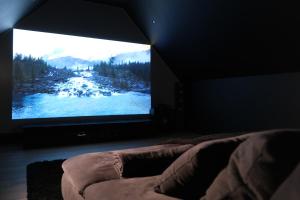 塞克兰Home Family Cinema的一间卧室,在房间内配有大屏幕电视