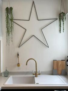 文特诺Top Deck - Fresh, stylish seaside apartment的挂在厨房水槽上方的大白星