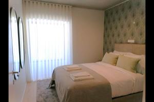里斯本Hidden Pearl W/ Patio & Pool by LovelyStay的一间卧室设有一张大床和一个窗户。
