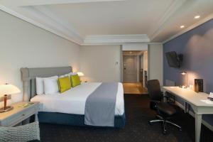 圣多明各圣多明各加泰罗尼亚酒店的配有一张床和一张书桌的酒店客房