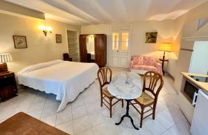 尼斯Résidence La Villa Léonie的卧室配有一张床和一张桌子及椅子