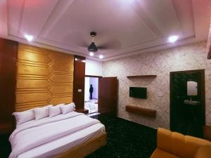 木尔坦The Signature Hotel Multan的卧室配有一张白色的大床和一张沙发。