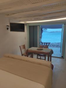 基莫洛斯岛Apanemo Beach House Agios Nikolaos Kimolos的客厅配有桌子,享有海景