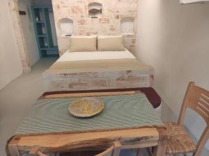基莫洛斯岛Apanemo Beach House Agios Nikolaos Kimolos的一间设有两张床的房间和一张带帽子的桌子