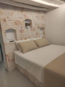 基莫洛斯岛Apanemo Beach House Agios Nikolaos Kimolos的石墙房间内的一张床位