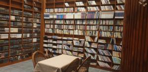 束草市红房子汽车旅馆的图书馆配有桌椅和书架