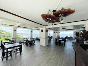 罗阿坦Ocean View Hotel and Restaurant的用餐室设有桌椅和窗户。