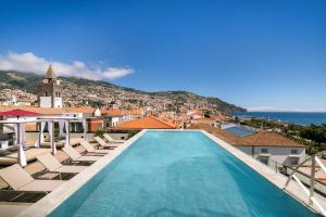 丰沙尔Barceló Funchal Oldtown的享有带椅子的游泳池和城市的景致。