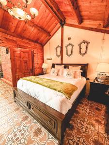克萨尔特南戈Casa Morasan Hotel-Boutique的一间带一张大床的卧室,位于一个拥有木制天花板的房间
