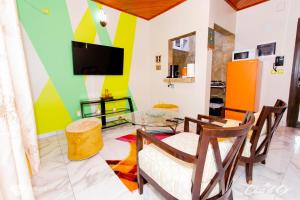 杜阿拉Clos d'Or, Appartements meublés Douala Makepé的客厅配有电视和桌椅