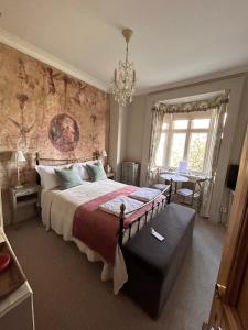 哈罗盖特哈泽尔庄园酒店的一间卧室配有一张大床和一个吊灯。