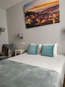 里斯本法克罗斯3号旅馆的卧室配有带蓝色枕头的大型白色床