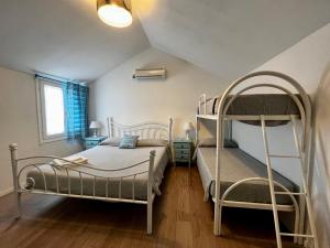 卡拉古诺内Camping Car Palmasera的一间卧室设有两张双层床和梯子